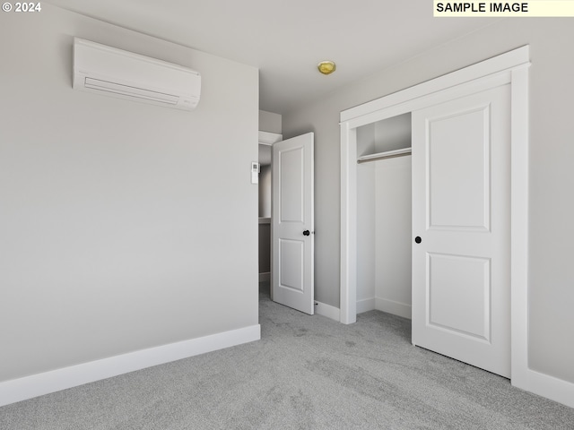 unfurnished bedroom featuring light carpet, a wall mounted air conditioner, and a closet