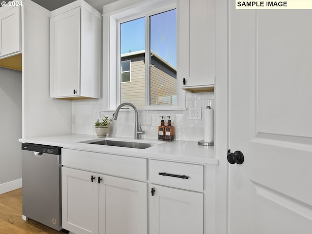 kitchen with sink, dishwasher, white cabinets, and backsplash