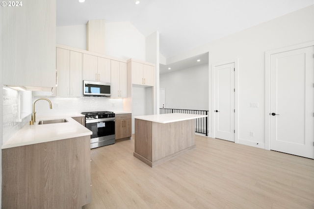 kitchen with decorative backsplash, a center island, light wood-type flooring, and appliances with stainless steel finishes