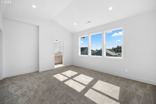 unfurnished bedroom featuring ensuite bathroom, carpet floors, and vaulted ceiling