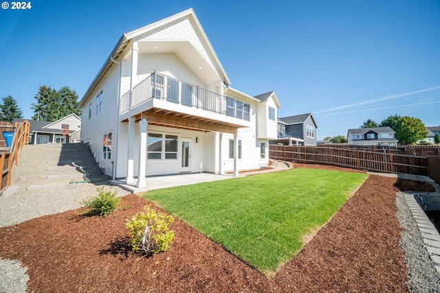 back of house featuring a balcony, a yard, and a patio