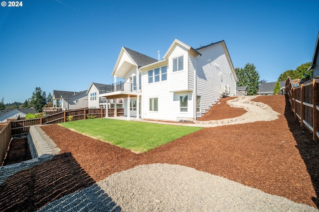 rear view of property with a patio area, a balcony, and a yard