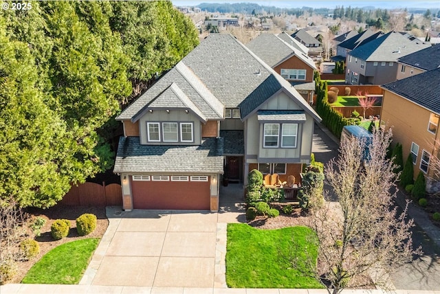 craftsman-style house featuring driveway, an attached garage, stucco siding, a shingled roof, and a residential view