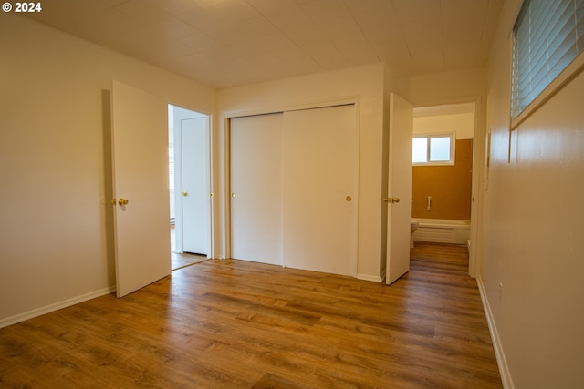 unfurnished bedroom featuring a closet and hardwood / wood-style flooring