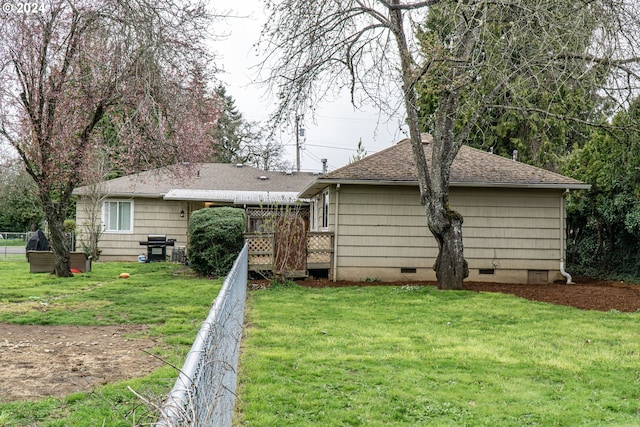 back of property with a deck and a yard