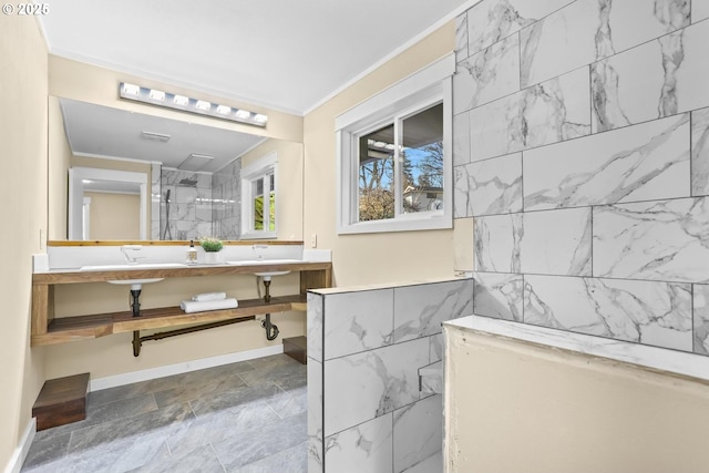 bathroom featuring ornamental molding, stone finish flooring, and a tile shower