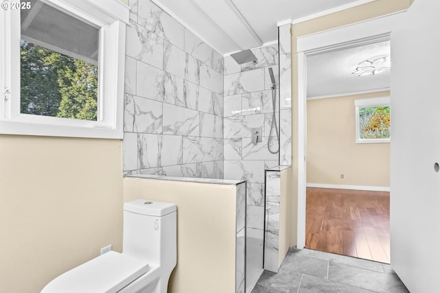 bathroom with walk in shower, toilet, and baseboards