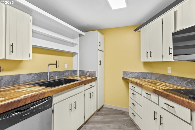 kitchen featuring open shelves, appliances with stainless steel finishes, light wood-style floors, a sink, and wood counters