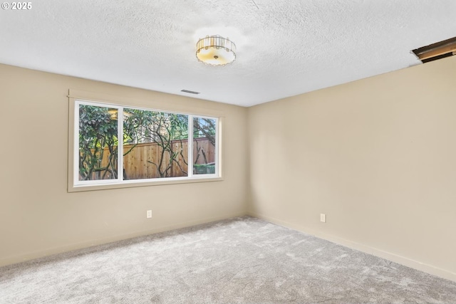 carpeted spare room with a textured ceiling and visible vents