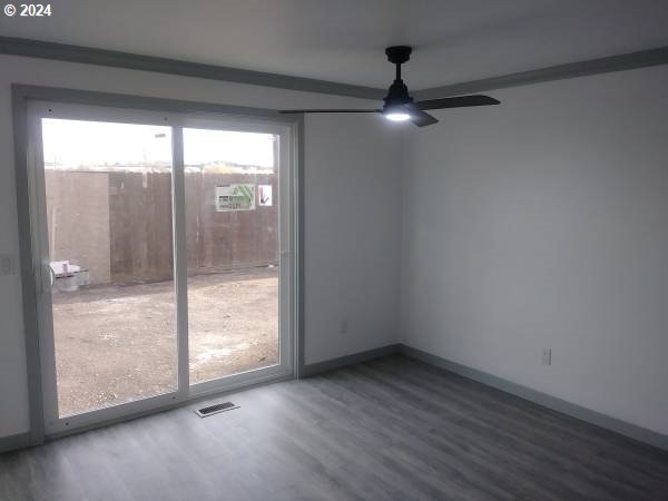 unfurnished room with ceiling fan, plenty of natural light, and hardwood / wood-style floors