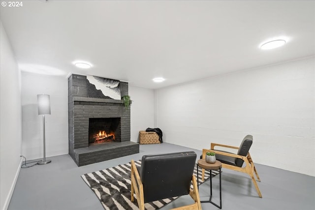 living room featuring concrete flooring and a brick fireplace