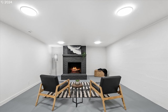 living area featuring concrete floors and a brick fireplace