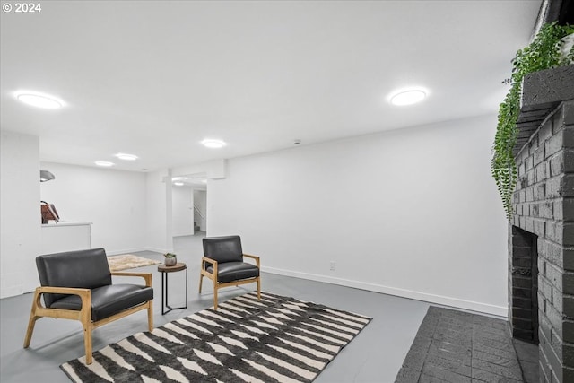 sitting room with a fireplace and concrete floors