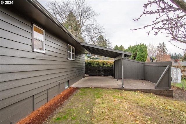 view of side of home with a yard and a patio