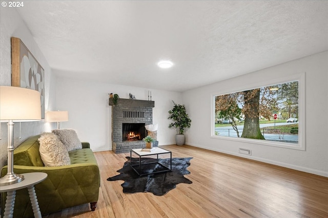 living room with hardwood / wood-style floors, a fireplace, and a textured ceiling