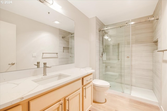 bathroom featuring toilet, an enclosed shower, vanity, and wood-type flooring