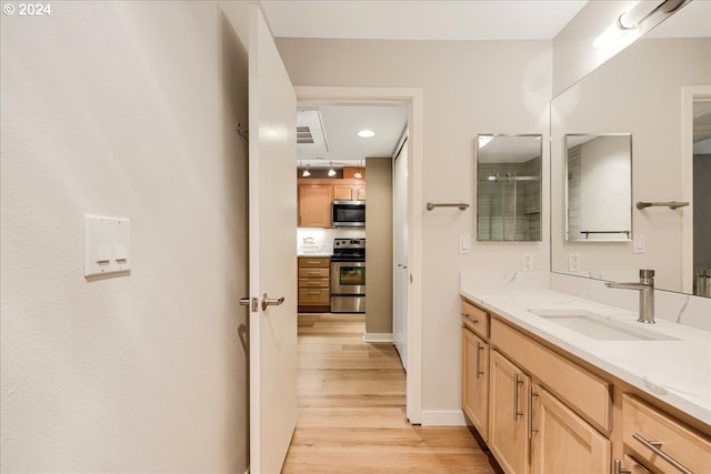 bathroom featuring an enclosed shower, vanity, and hardwood / wood-style flooring