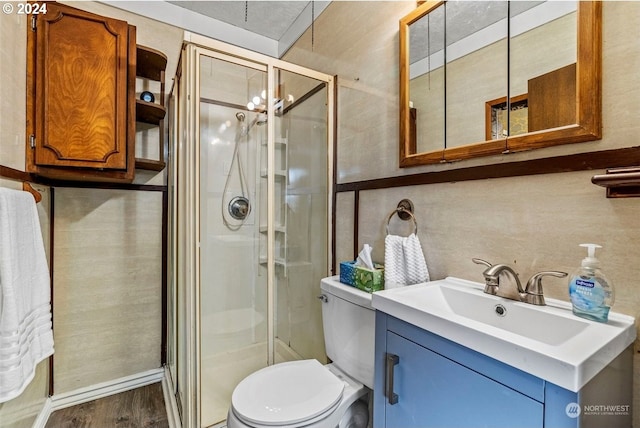 bathroom with hardwood / wood-style floors, vanity, toilet, and a shower with shower door