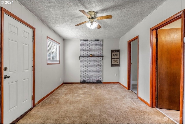 empty room featuring light carpet, a textured ceiling, and ceiling fan