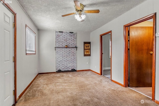 unfurnished bedroom featuring ceiling fan, ensuite bathroom, light carpet, and a textured ceiling