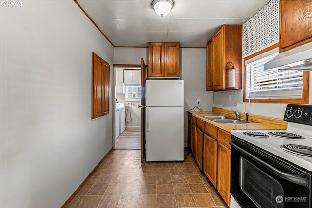 kitchen featuring washer and clothes dryer, white appliances, sink, and extractor fan