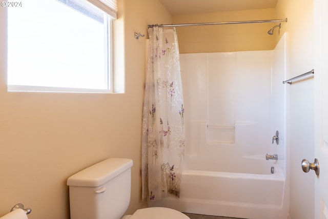 bathroom featuring toilet, a wealth of natural light, and shower / bath combo with shower curtain