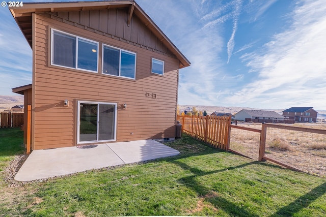 rear view of property with a lawn and a patio