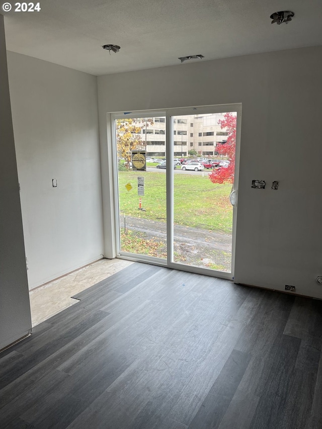 empty room featuring a textured ceiling and hardwood / wood-style flooring