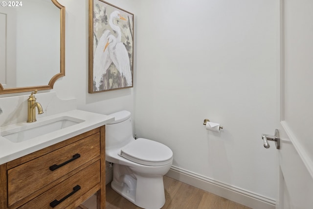 bathroom featuring vanity, toilet, and hardwood / wood-style floors