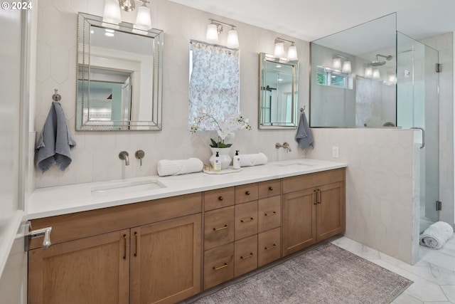 bathroom featuring a shower with shower door and vanity