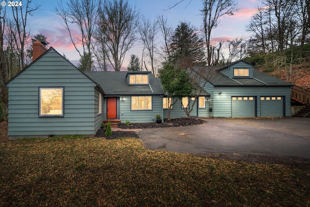 view of front of property featuring aphalt driveway, an attached garage, and a shingled roof