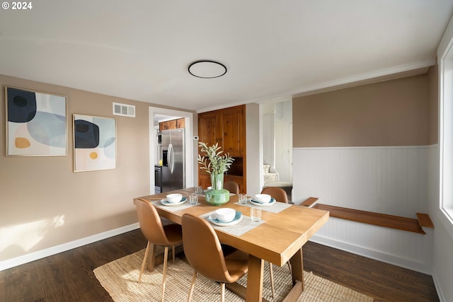 dining area featuring stairway, baseboards, visible vents, dark wood finished floors, and wainscoting