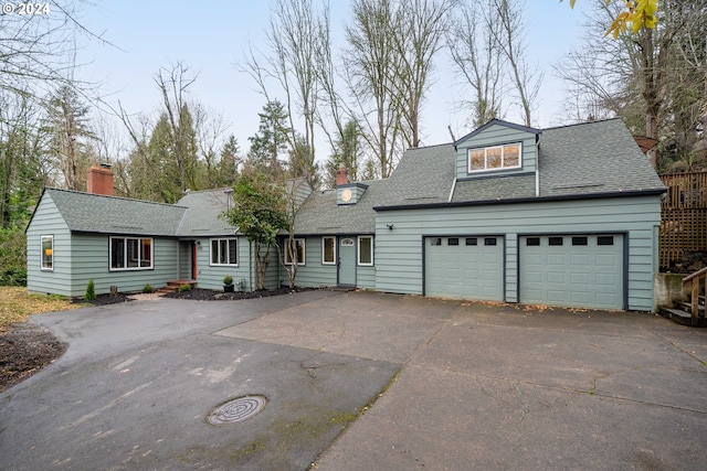 view of front of house with aphalt driveway, a garage, roof with shingles, and a chimney