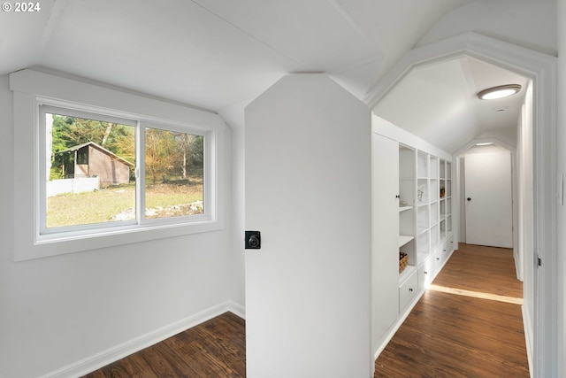 hall featuring baseboards, lofted ceiling, and dark wood-style flooring