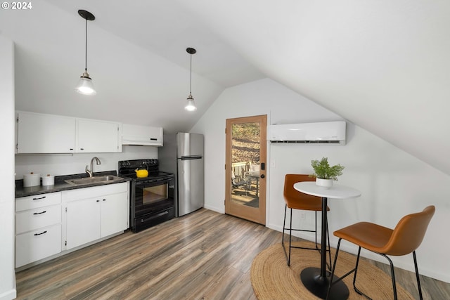 kitchen featuring dark countertops, freestanding refrigerator, electric range, a wall mounted AC, and a sink