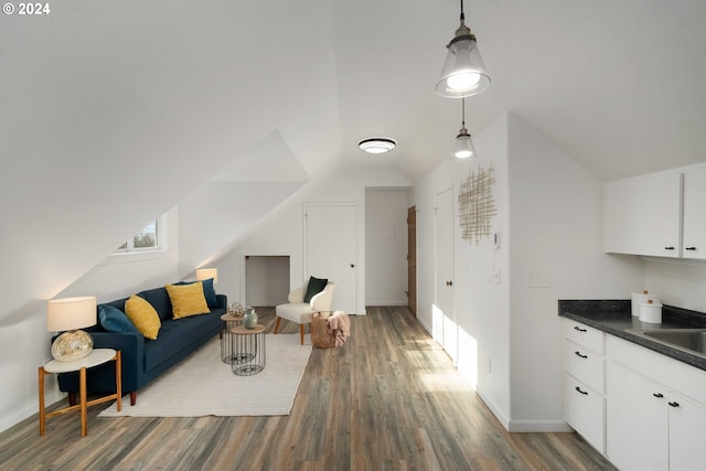 living area featuring baseboards, wood finished floors, and vaulted ceiling