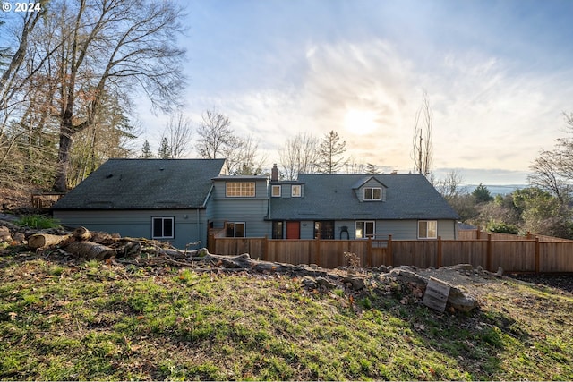 rear view of house featuring fence