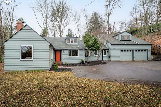 view of front of property with driveway, a shingled roof, and a garage