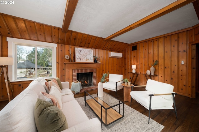 living area featuring beam ceiling, a wall mounted AC, wood finished floors, wood walls, and a brick fireplace