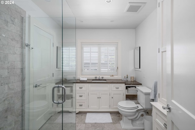 bathroom featuring tile patterned flooring, vanity, an enclosed shower, and toilet