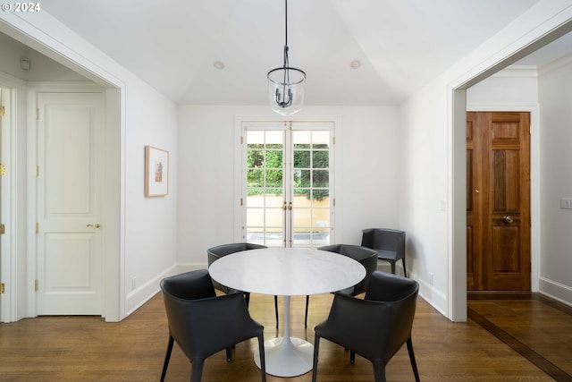 dining room with french doors, hardwood / wood-style flooring, lofted ceiling, and a notable chandelier