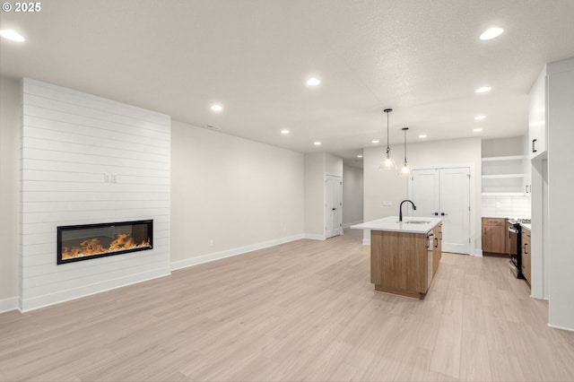 12010 SW Trask St Unit Lt94, Beaverton, OR 97007 - kitchen with recessed lighting, open floor plan, light wood finished floors, a kitchen island with sink, and light countertops