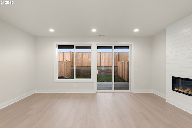 12010 SW Trask St Unit Lt94, Beaverton, OR 97007 - unfurnished living room with light wood-type flooring, plenty of natural light, baseboards, recessed lighting, and a large fireplace