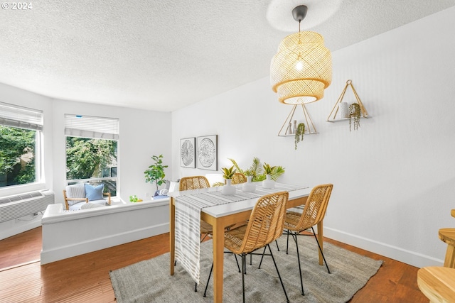 dining area featuring a textured ceiling, cooling unit, and hardwood / wood-style flooring