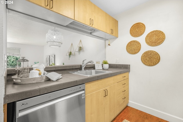 kitchen featuring light brown cabinetry, dishwasher, hardwood / wood-style floors, and sink