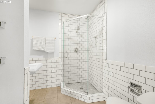 bathroom with walk in shower, tile walls, tile patterned flooring, and toilet