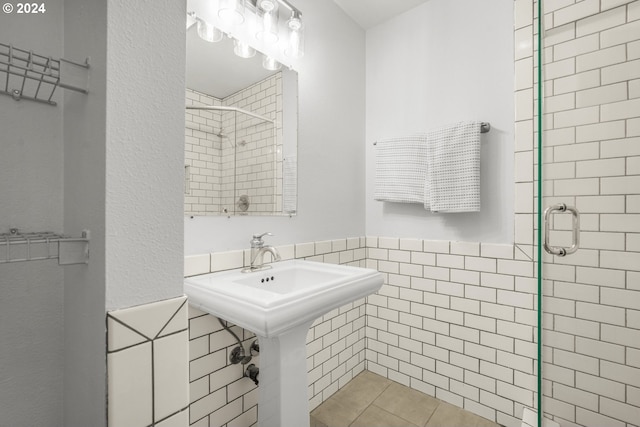 bathroom featuring tile walls and a shower with shower door