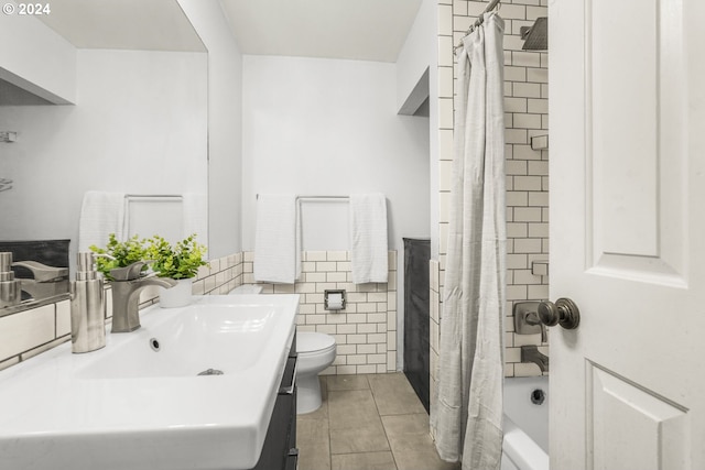 full bathroom featuring tile walls, tile patterned floors, shower / bath combo with shower curtain, vanity, and toilet