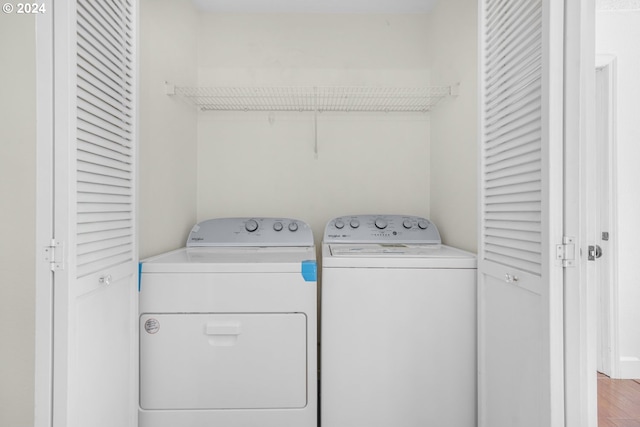 clothes washing area with hardwood / wood-style floors and separate washer and dryer