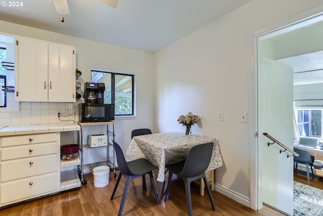 dining space with wood-type flooring and ceiling fan